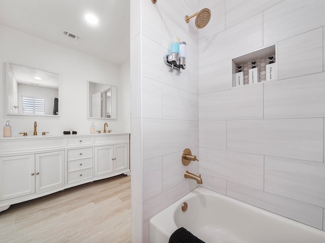 8007 Beluche Dr, Galveston, TX 77551 - full bathroom with a sink, visible vents, double vanity, shower / bathtub combination, and wood finished floors