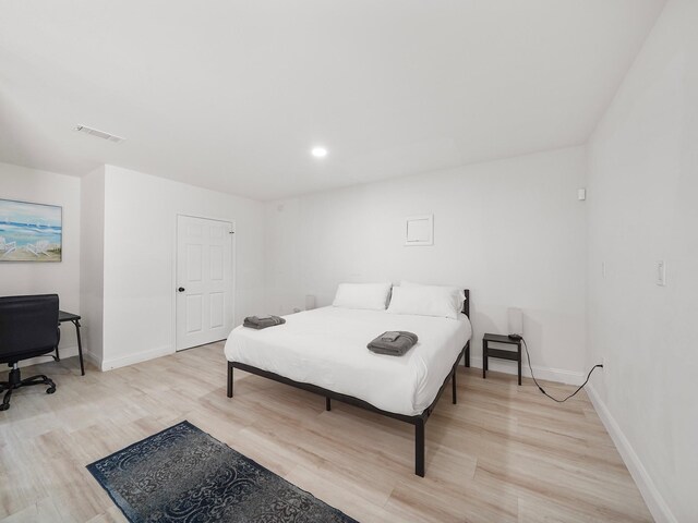 8007 Beluche Dr, Galveston, TX 77551 - bedroom with baseboards, light wood-style floors, and visible vents