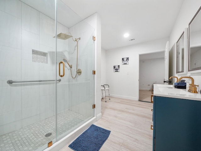 8007 Beluche Dr, Galveston, TX 77551 - bathroom with a shower stall, baseboards, wood finished floors, and double vanity