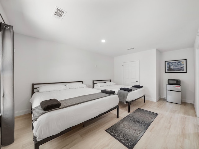 8007 Beluche Dr, Galveston, TX 77551 - bedroom with light wood-style flooring, baseboards, and visible vents