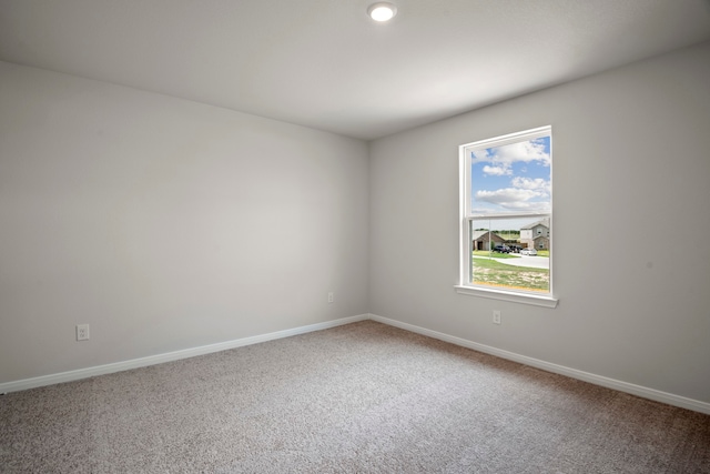 spare room featuring carpet floors and baseboards