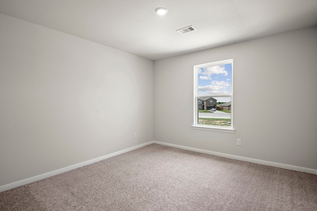 spare room featuring carpet, baseboards, and visible vents