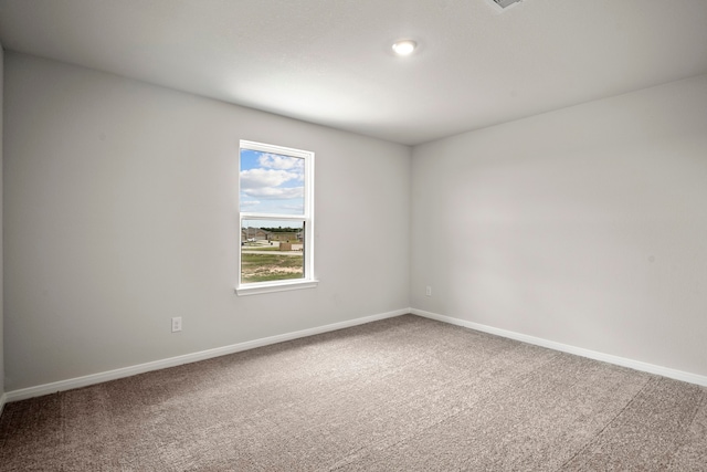 spare room with baseboards and carpet flooring