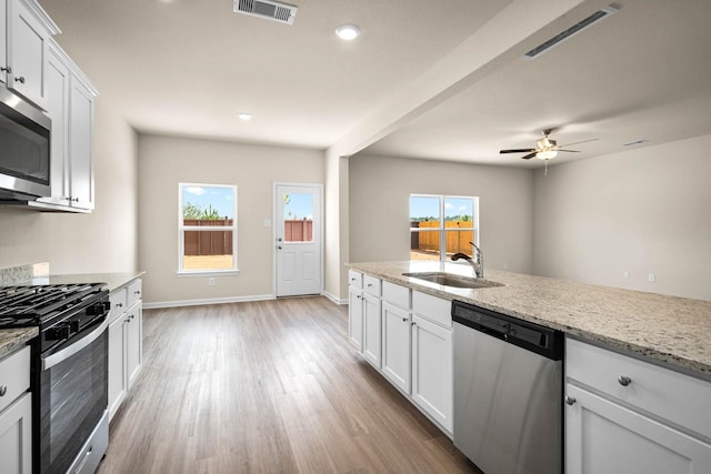 kitchen with light wood-style flooring, a sink, stainless steel appliances, and visible vents