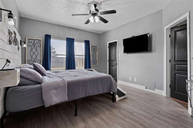 7529 Topaz Way, Texas City, TX 77591 - bedroom with baseboards, a textured ceiling, wood finish floors, and a ceiling fan