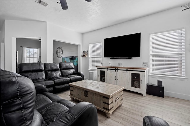 7529 Topaz Way, Texas City, TX 77591 - living area with a textured ceiling, light wood-style flooring, visible vents, baseboards, and a ceiling fan