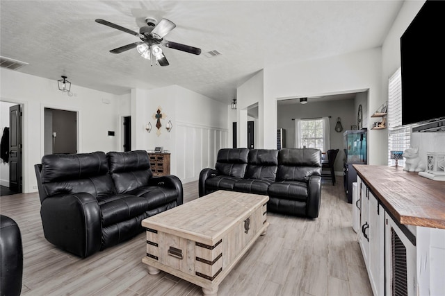 7529 Topaz Way, Texas City, TX 77591 - living room featuring a textured ceiling, beverage cooler, light wood-type flooring, visible vents, and ceiling fan