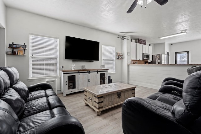 7529 Topaz Way, Texas City, TX 77591 - living room with a ceiling fan, light wood-style flooring, visible vents, and a textured ceiling
