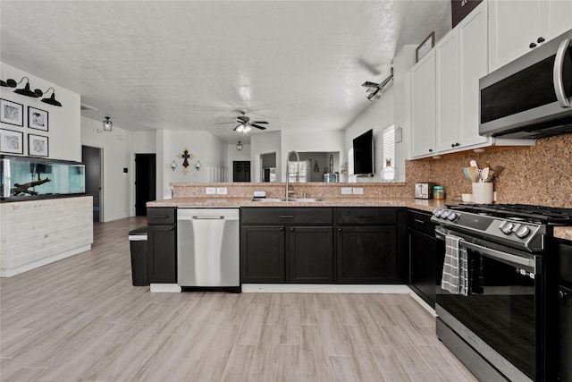7529 Topaz Way, Texas City, TX 77591 - kitchen featuring open floor plan, white cabinetry, a ceiling fan, a peninsula, and appliances with stainless steel finishes
