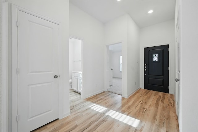 foyer entrance featuring baseboards, light wood-style floors, and recessed lighting