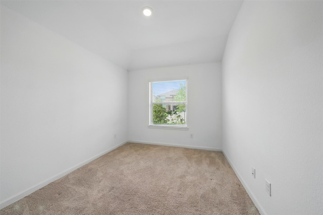 spare room featuring baseboards and light colored carpet