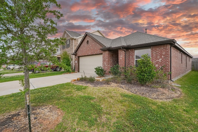 view of front facade featuring a front yard, concrete driveway, brick siding, a shingled roof, and a garage