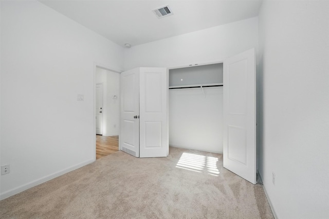 unfurnished bedroom with carpet floors, a closet, baseboards, and visible vents