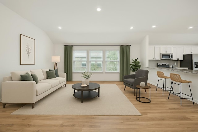 living area featuring light wood-style flooring, baseboards, vaulted ceiling, and recessed lighting