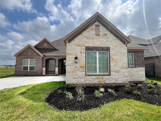 view of front of property with a front lawn, stone siding, and a shingled roof