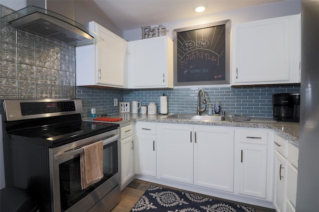 kitchen with a sink, decorative backsplash, wall chimney range hood, and appliances with stainless steel finishes