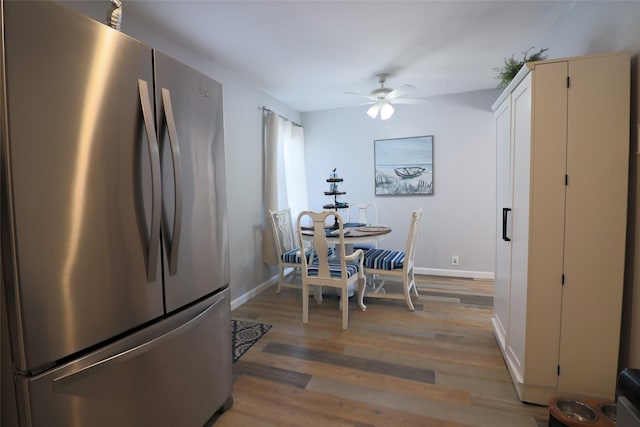 dining space featuring a ceiling fan, baseboards, and light wood-style flooring
