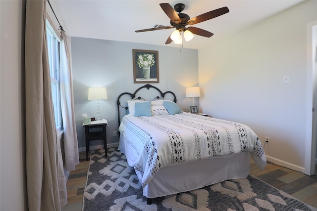 bedroom with baseboards, wood finished floors, and a ceiling fan