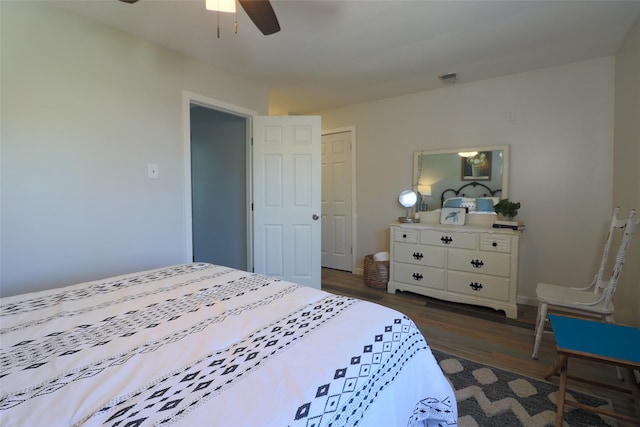 bedroom with baseboards, visible vents, dark wood-type flooring, and a ceiling fan