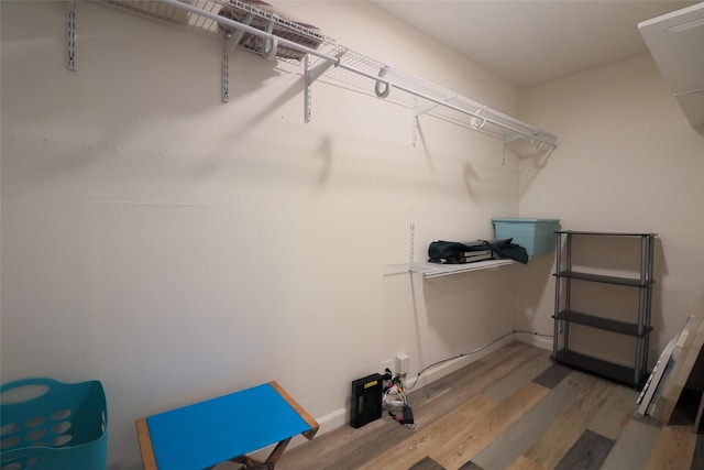 walk in closet with wood finished floors