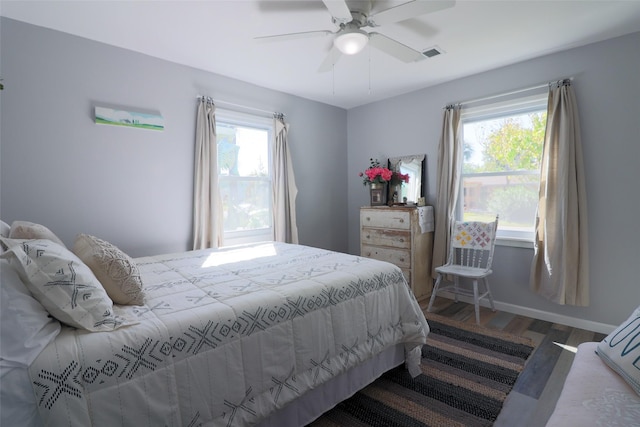 bedroom featuring multiple windows, visible vents, wood finished floors, and baseboards