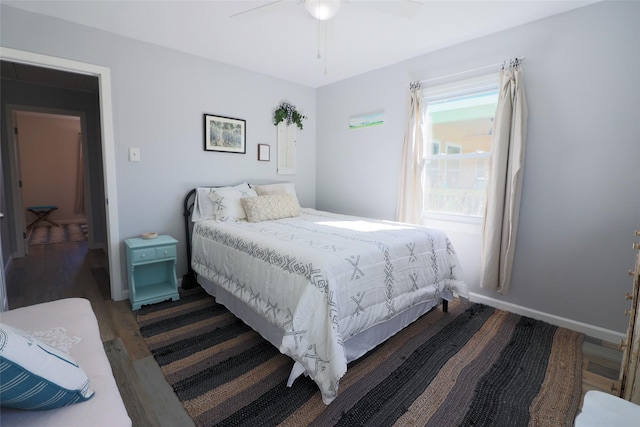 bedroom with baseboards, wood finished floors, and a ceiling fan
