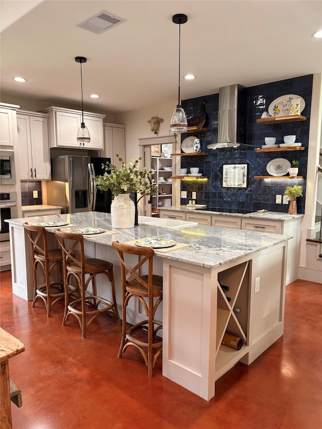 kitchen with open shelves, appliances with stainless steel finishes, concrete floors, wall chimney range hood, and a kitchen island