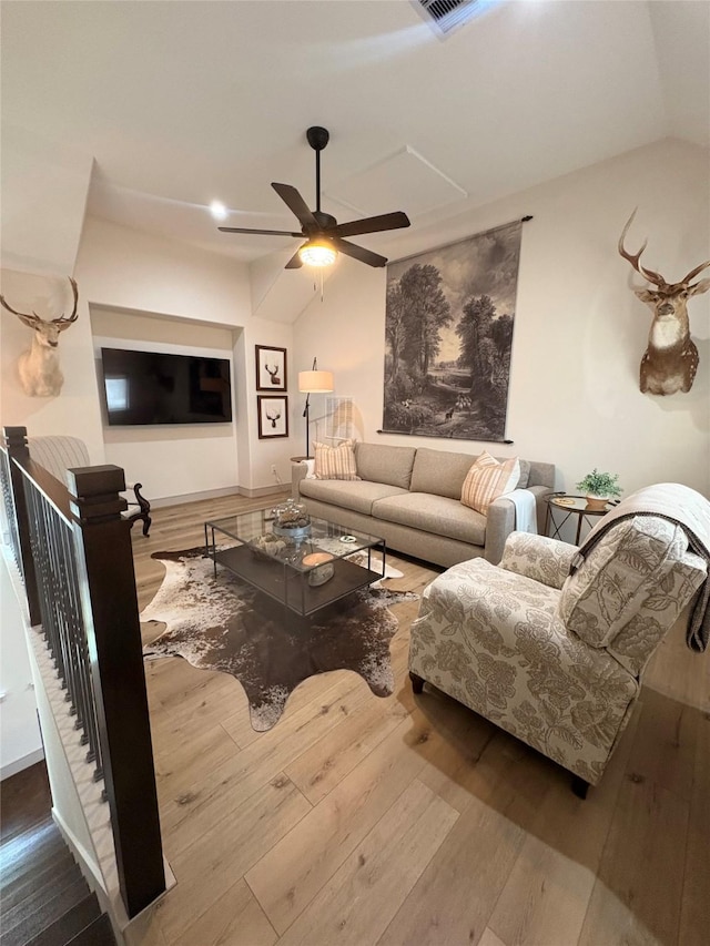 living area featuring lofted ceiling, ceiling fan, and hardwood / wood-style flooring