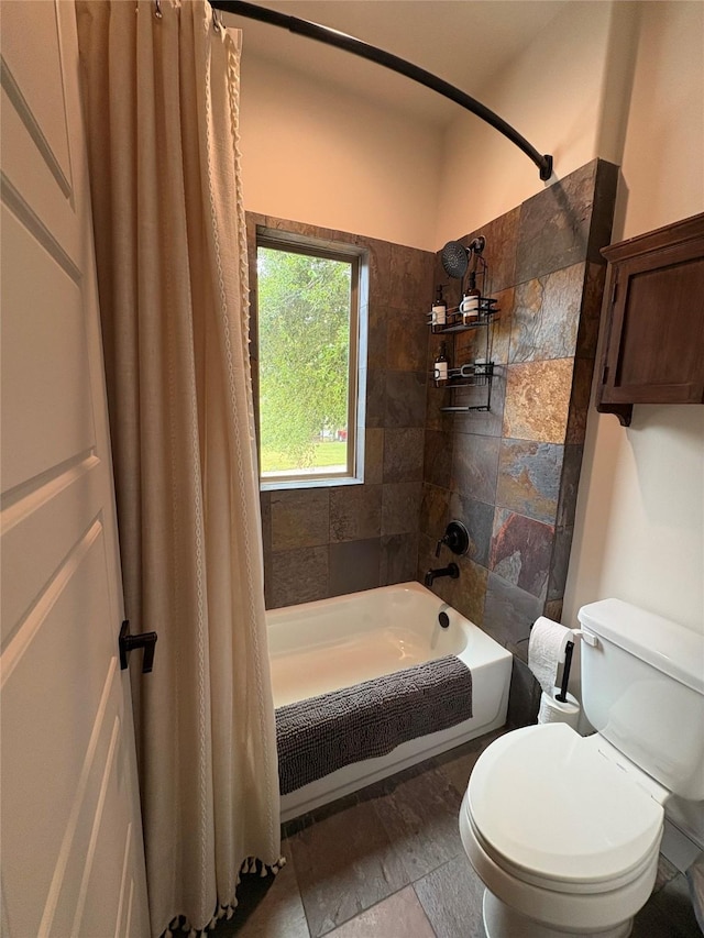 bathroom featuring toilet, shower / bath combination with curtain, and stone finish floor
