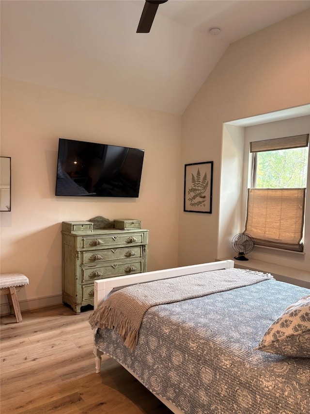 bedroom with lofted ceiling, ceiling fan, wood finished floors, and baseboards
