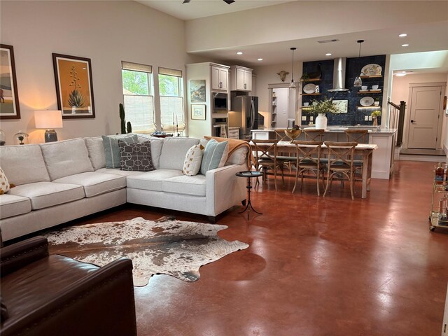 living area featuring recessed lighting, ceiling fan, finished concrete flooring, and visible vents