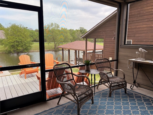 sunroom featuring a water view