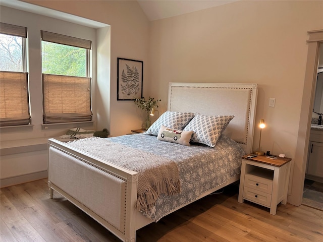 bedroom featuring light wood-type flooring and lofted ceiling