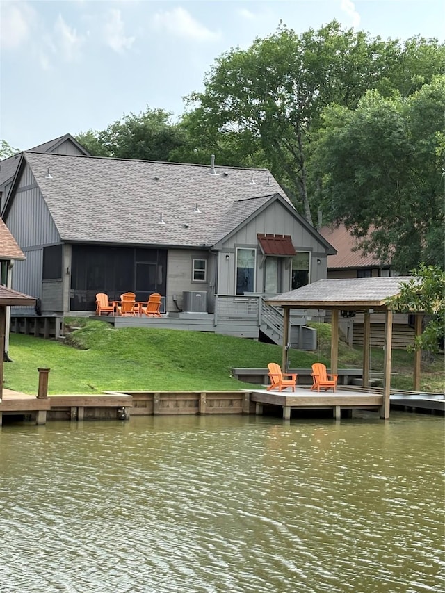 view of dock featuring a lawn, central AC, and a deck with water view