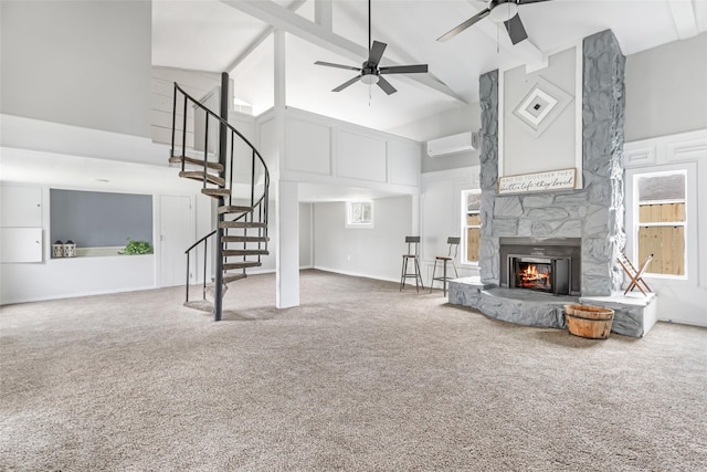 11610 Lane St, Houston, TX 77029 - living room featuring carpet flooring, a wall mounted AC, a fireplace, high vaulted ceiling, and ceiling fan