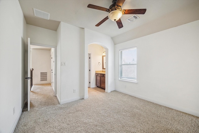 27 Tioga Pl, The Woodlands, TX 77375 - unfurnished bedroom with light colored carpet, arched walkways, baseboards, a ceiling fan, and connected bathroom