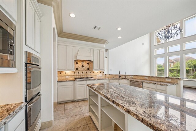 27 Tioga Pl, The Woodlands, TX 77375 - kitchen featuring appliances with stainless steel finishes, a sink, tasteful backsplash, a chandelier, and recessed lighting