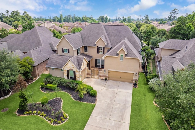 27 Tioga Pl, The Woodlands, TX 77375 - view of front of house featuring stone siding, driveway, a garage, stucco siding, and a shingled roof