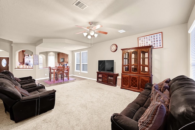 2606 Howlite Ln, Rosharon, TX 77583 - carpeted living room with arched walkways, baseboards, visible vents, and a ceiling fan