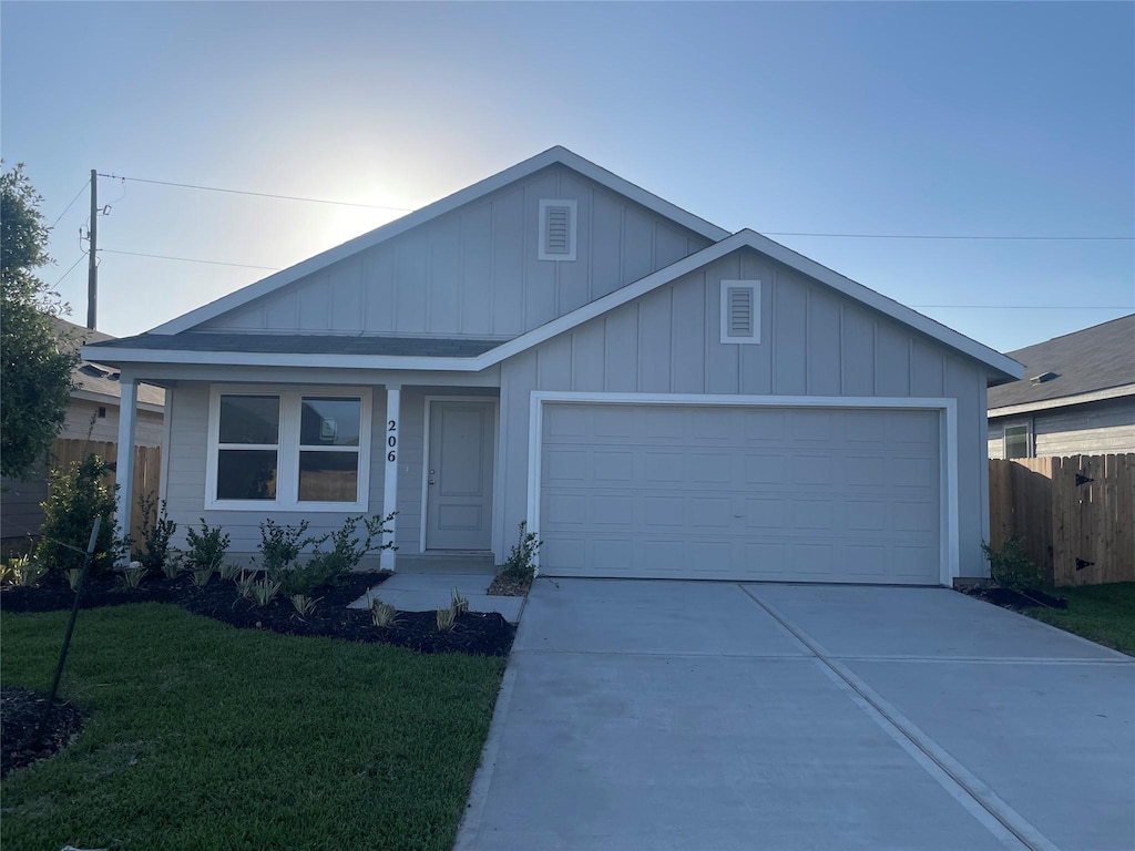ranch-style home featuring fence, a front lawn, concrete driveway, board and batten siding, and a garage