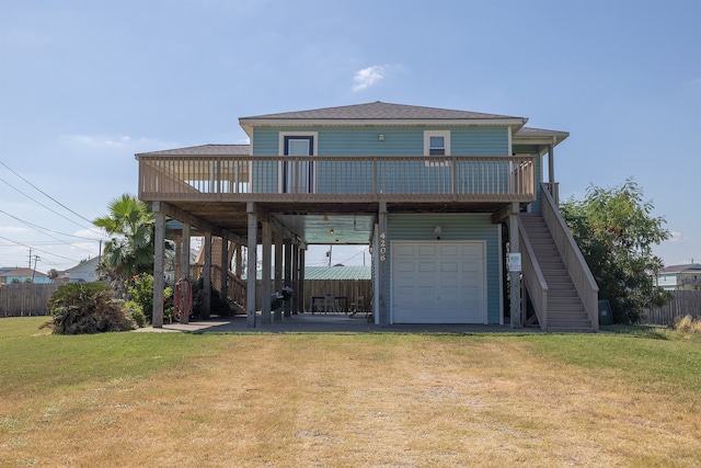 4206 Seabird Dr, Galveston, TX 77554 - back of property featuring stairway, a garage, a wooden deck, a shingled roof, and driveway
