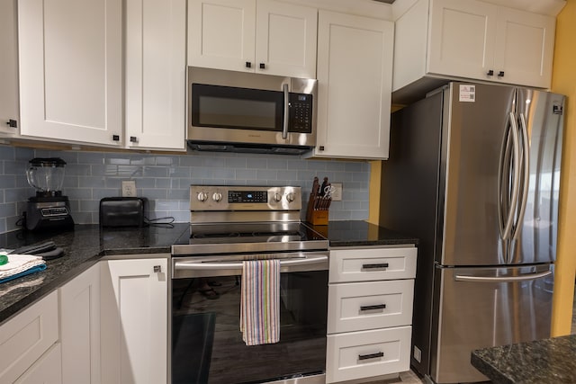 4206 Seabird Dr, Galveston, TX 77554 - kitchen with stainless steel appliances, white cabinets, backsplash, and dark stone counters
