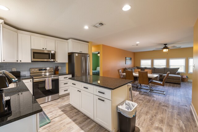 4206 Seabird Dr, Galveston, TX 77554 - kitchen featuring stainless steel appliances, light wood-style flooring, white cabinetry, backsplash, and recessed lighting