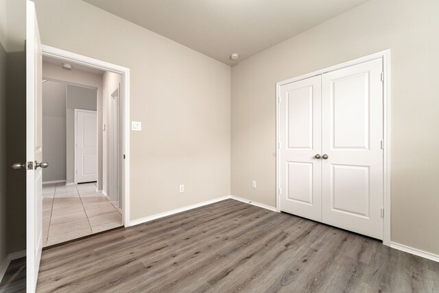 5014 Aspen Orchard Dr, Houston, TX 77066 - unfurnished bedroom featuring wood finished floors, baseboards, and a closet
