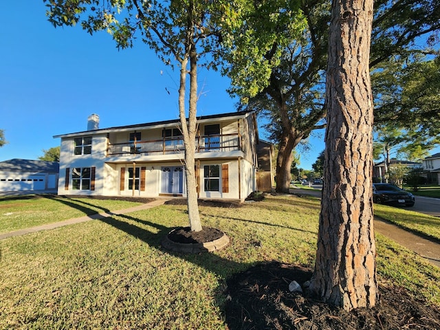 rear view of property featuring a yard and a balcony