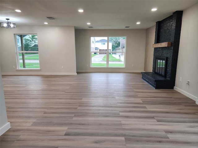 unfurnished living room with recessed lighting, a healthy amount of sunlight, a fireplace, and visible vents