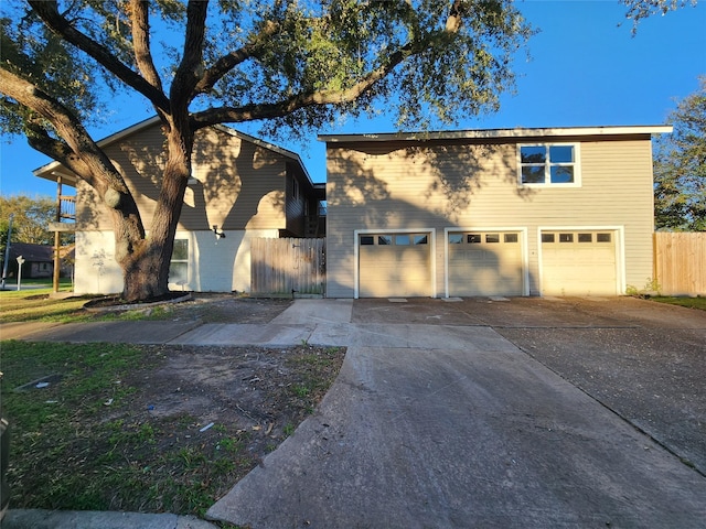 traditional-style home with concrete driveway, fence, and a garage