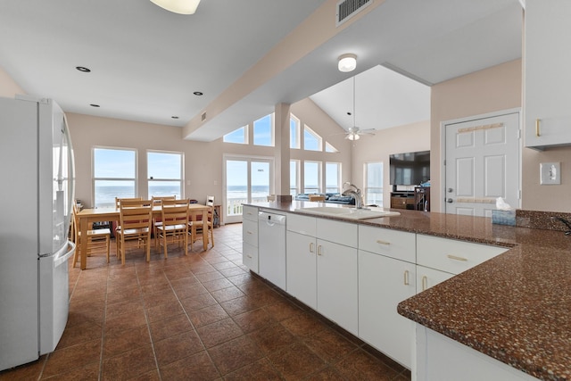 22915 Gulf Dr, Galveston, TX 77554 - kitchen featuring white cabinets, visible vents, white appliances, dark stone countertops, and a sink