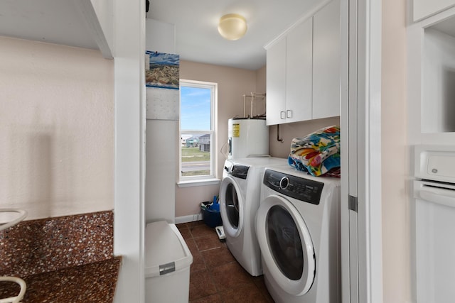 22915 Gulf Dr, Galveston, TX 77554 - washroom with baseboards, electric water heater, washing machine and clothes dryer, and dark tile patterned flooring