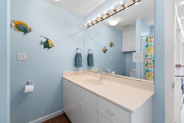 22915 Gulf Dr, Galveston, TX 77554 - full bathroom with toilet, vanity, tile patterned flooring, and baseboards